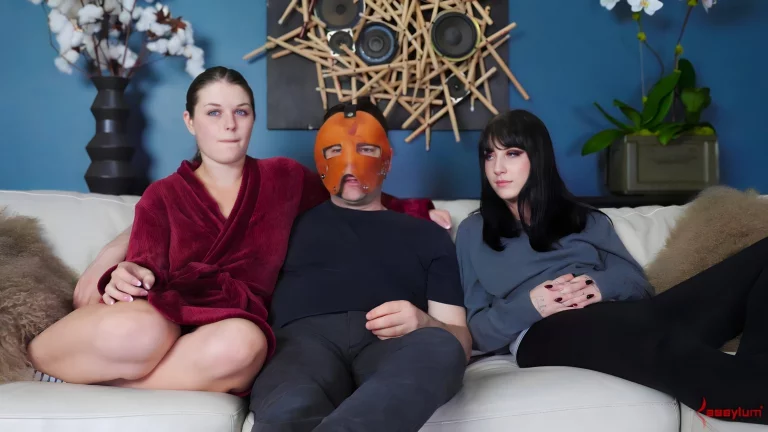 ⁣Two Beautiful Girls And A Masked Man Sit And Talk On The Couch 